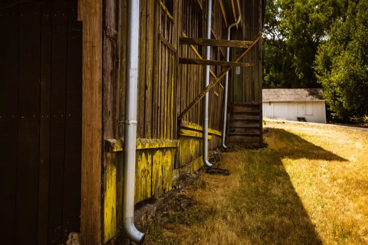 Roof edge, fascia and downspout on a house in Greenwood, IN, where drip edge carries runoff into the gutter